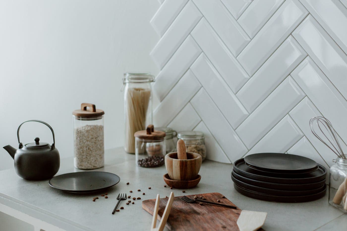 A stoneware bowl with wooden spoons on a warm linen tablecloth